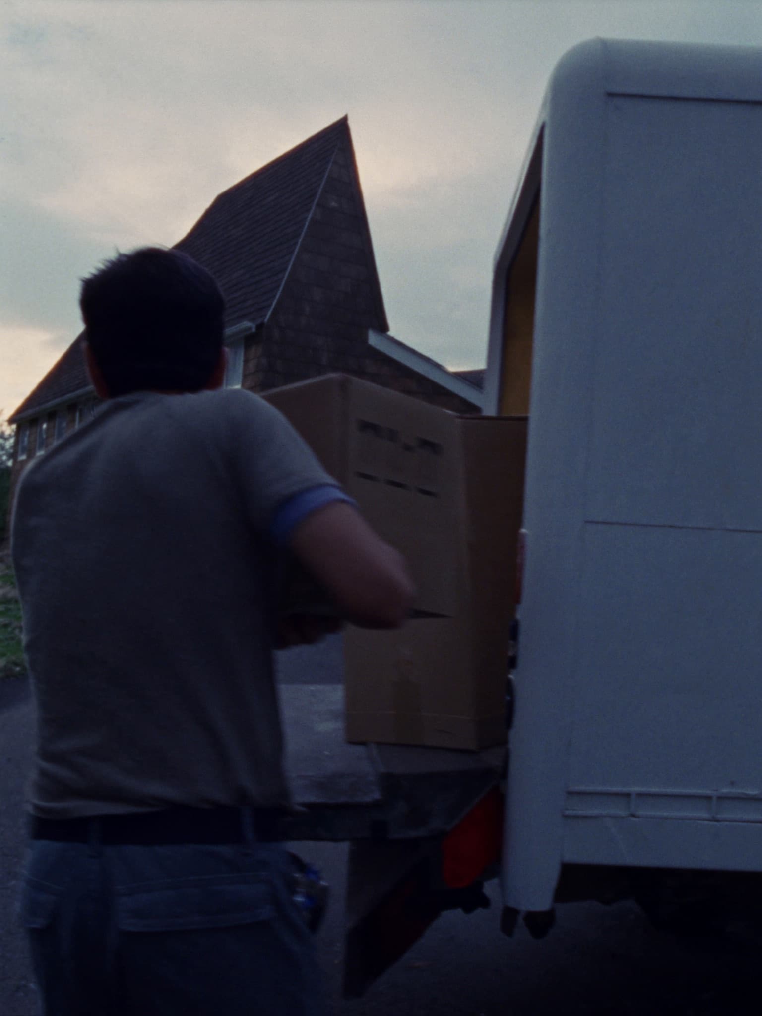 A Mazheika crew member loading a box into the truck at dusk